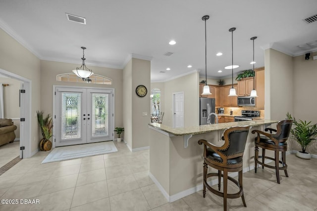 kitchen featuring visible vents, appliances with stainless steel finishes, ornamental molding, light stone countertops, and french doors