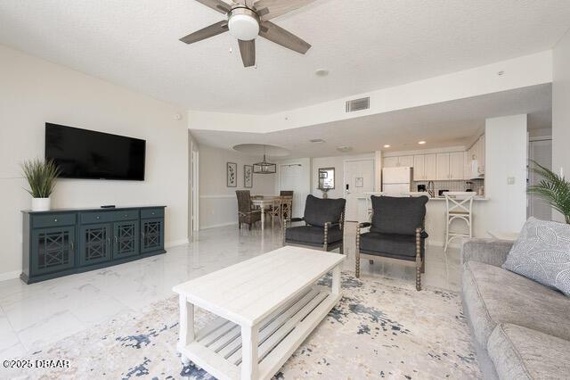 living room featuring marble finish floor, recessed lighting, visible vents, a ceiling fan, and baseboards