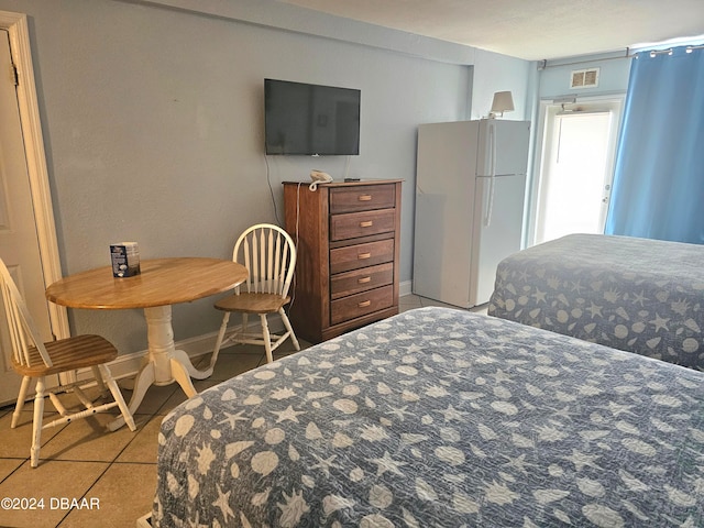 tiled bedroom featuring white refrigerator