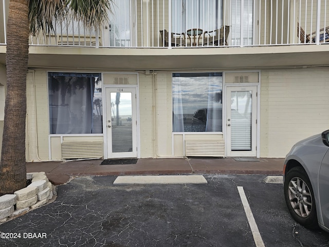 1233 S Atlantic Ave Unit 1030, Daytona Beach, FL 32118 - view of exterior entry with a balcony and uncovered parking