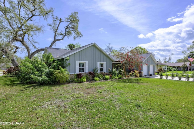 ranch-style home with a front lawn, board and batten siding, and an attached garage