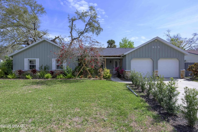 ranch-style house with a front yard, stone siding, an attached garage, and concrete driveway