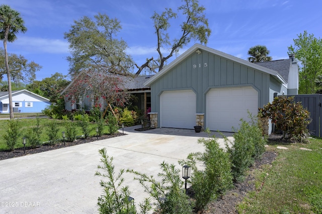 view of front of house featuring board and batten siding, concrete driveway, stone siding, and an attached garage