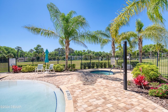 view of swimming pool with a community hot tub and a patio