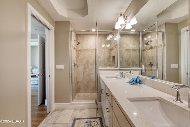 bathroom featuring tile patterned floors, a shower with door, and vanity