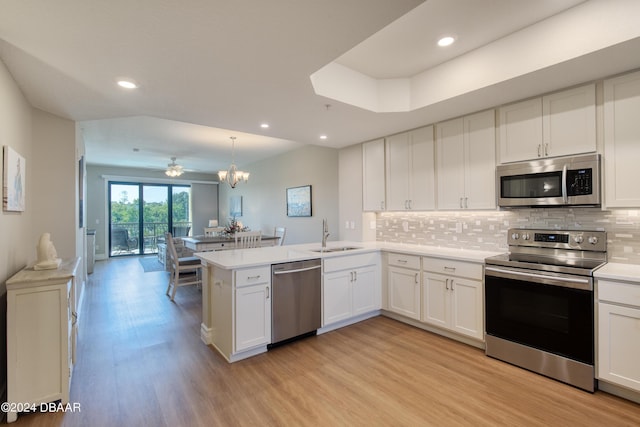 kitchen with white cabinets, kitchen peninsula, and appliances with stainless steel finishes