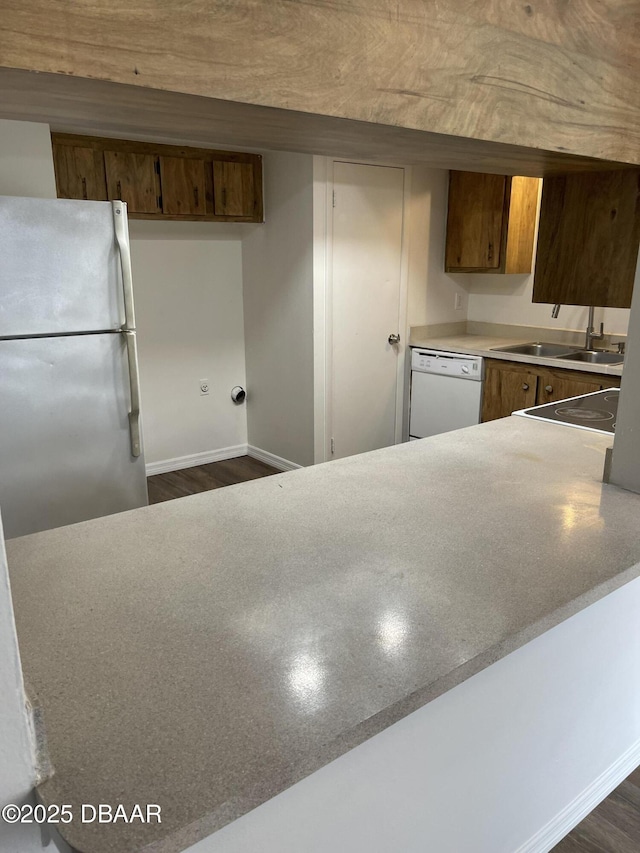 428 Banana Cay Dr Unit G, South Daytona, FL 32119 - kitchen with white appliances, a sink, baseboards, and brown cabinetry