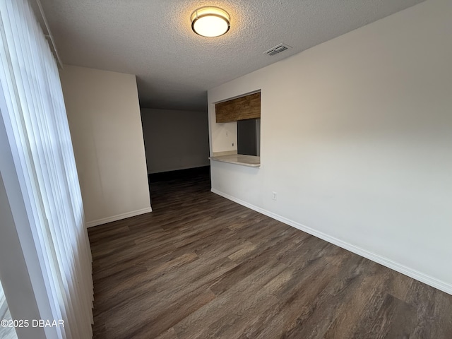 428 Banana Cay Dr Unit G, South Daytona, FL 32119 - spare room with dark wood-style flooring, a textured ceiling, and baseboards