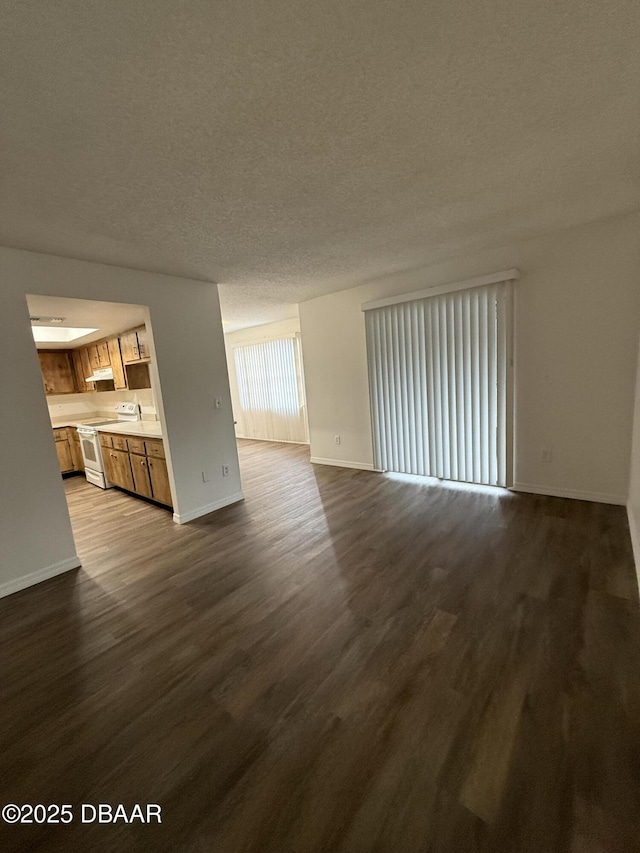 428 Banana Cay Dr Unit G, South Daytona, FL 32119 - unfurnished living room with dark wood-style floors, baseboards, and a textured ceiling
