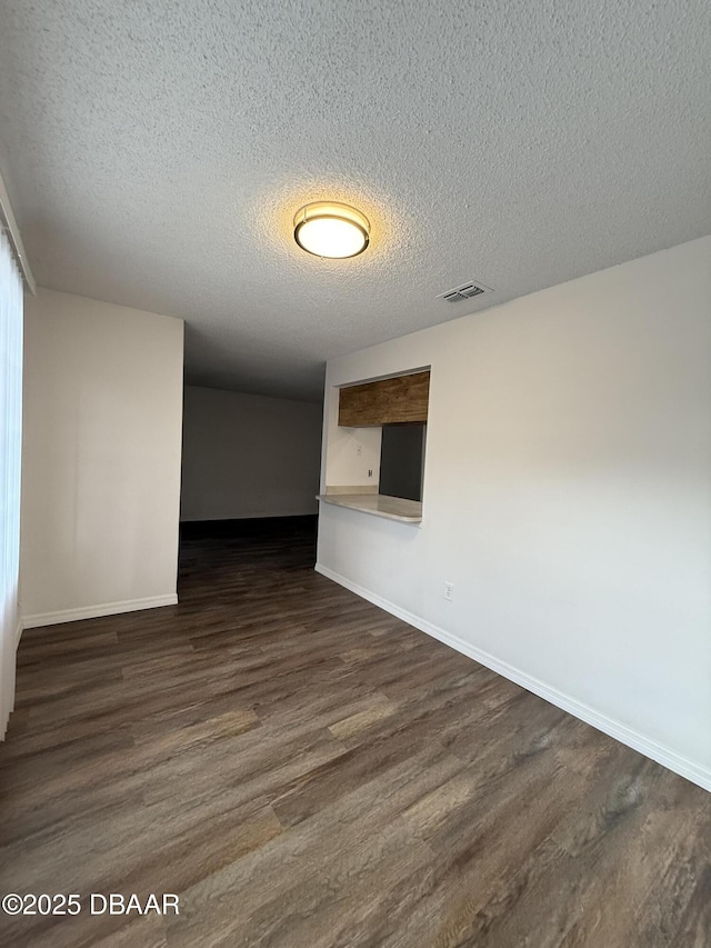 428 Banana Cay Dr Unit G, South Daytona, FL 32119 - unfurnished room featuring dark wood-type flooring, a textured ceiling, and baseboards