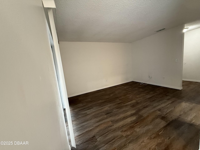 428 Banana Cay Dr Unit G, South Daytona, FL 32119 - spare room with a textured ceiling, dark wood-style flooring, and baseboards