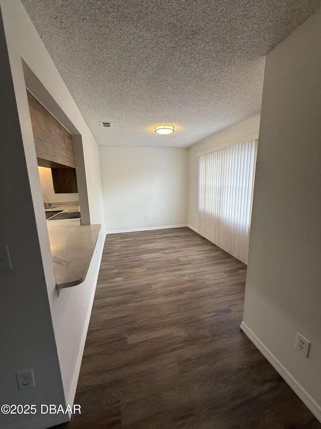428 Banana Cay Dr Unit G, South Daytona, FL 32119 - empty room featuring baseboards, dark wood finished floors, and a textured ceiling