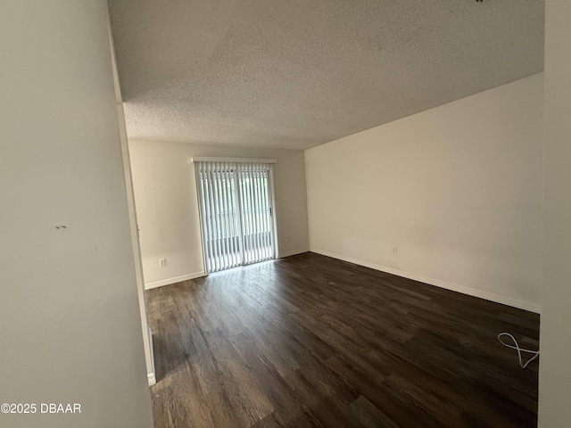 428 Banana Cay Dr Unit G, South Daytona, FL 32119 - unfurnished room with dark wood-style flooring, baseboards, and a textured ceiling