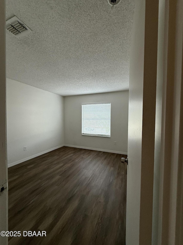 428 Banana Cay Dr Unit G, South Daytona, FL 32119 - spare room featuring a textured ceiling, dark wood finished floors, and baseboards