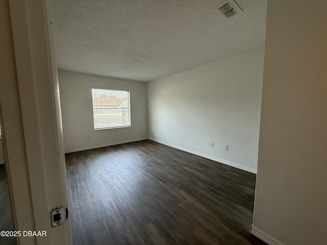 428 Banana Cay Dr Unit G, South Daytona, FL 32119 - empty room with dark wood-style floors, a textured ceiling, and baseboards
