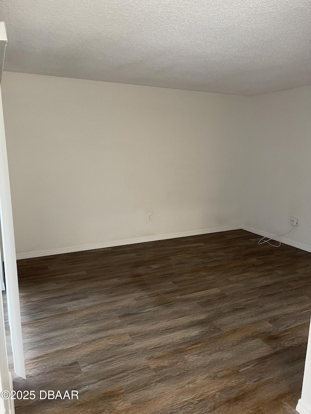 428 Banana Cay Dr Unit G, South Daytona, FL 32119 - empty room featuring dark wood-style floors, a textured ceiling, and baseboards