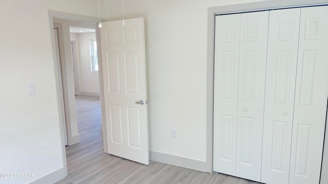 unfurnished bedroom featuring light hardwood / wood-style flooring and a closet