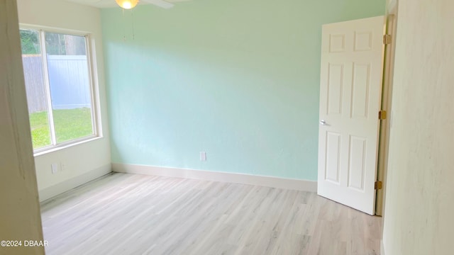 unfurnished room with a wealth of natural light, ceiling fan, and light hardwood / wood-style flooring