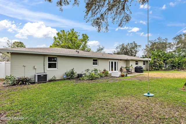 rear view of house with a yard, cooling unit, and french doors