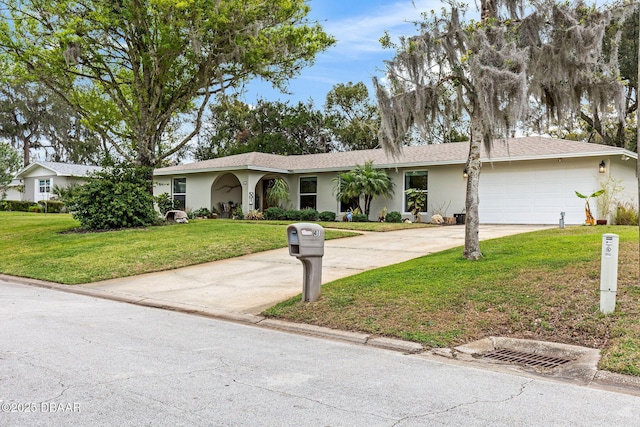 single story home with driveway, a front lawn, an attached garage, and stucco siding