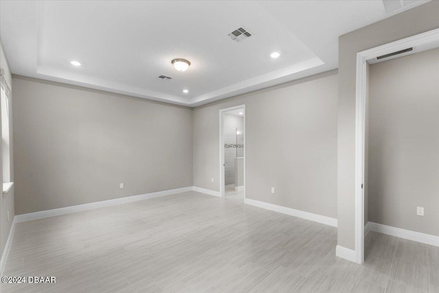 unfurnished room with a raised ceiling