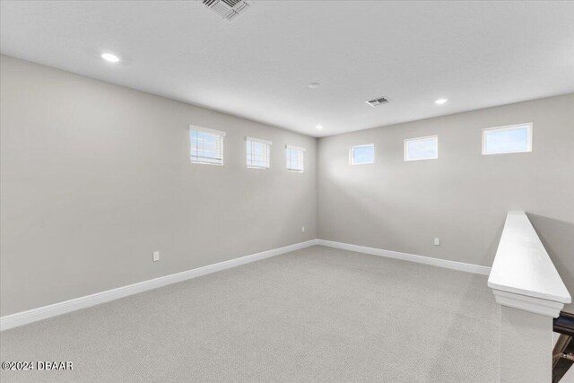 basement with a wealth of natural light and carpet flooring