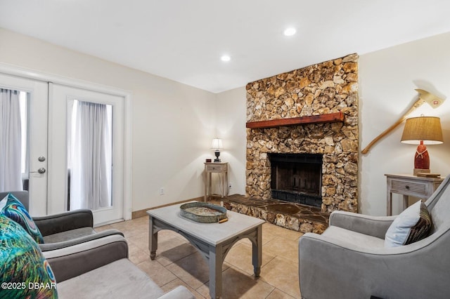 living room with a stone fireplace and light tile patterned floors