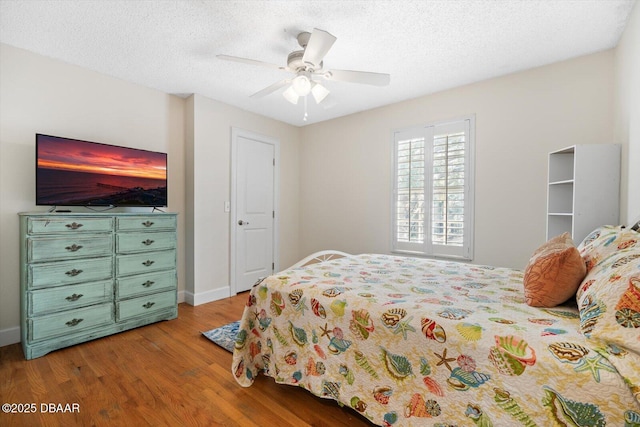 bedroom featuring ceiling fan, a textured ceiling, and light wood-type flooring