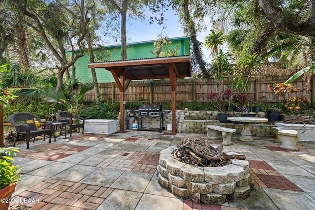 view of patio / terrace featuring a gazebo, grilling area, and a fire pit