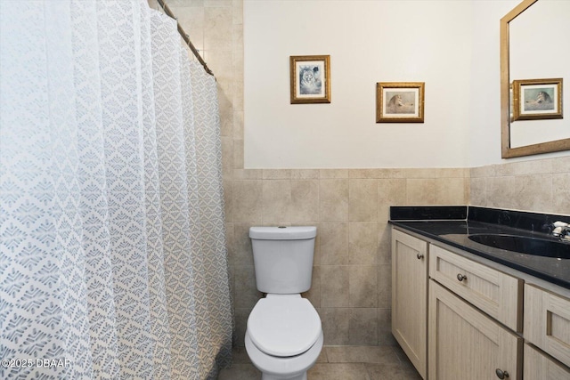 bathroom with tile patterned flooring, vanity, tile walls, and toilet