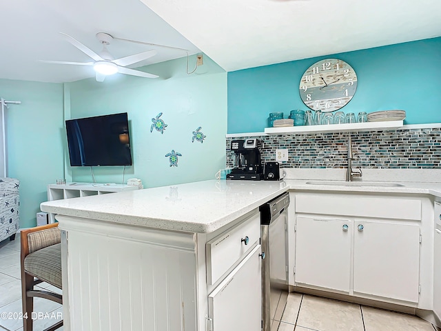 kitchen with white cabinets, decorative backsplash, stainless steel dishwasher, and sink