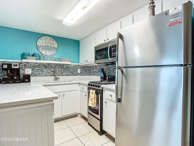 kitchen featuring stainless steel appliances, white cabinets, sink, and tasteful backsplash