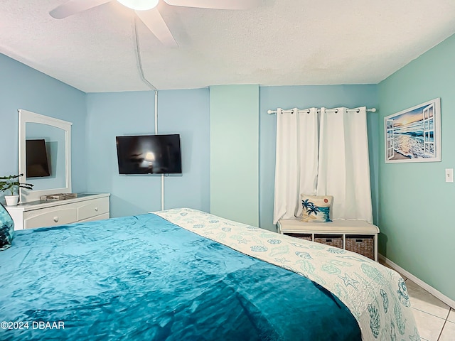 bedroom with light tile patterned flooring, a textured ceiling, and ceiling fan