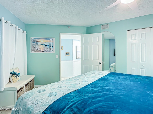 bedroom featuring a textured ceiling, ceiling fan, and a closet