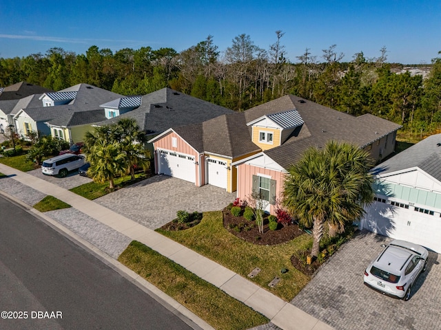 711 Attitude Ave, Daytona Beach, FL 32124 - view of front of property with gravel driveway, board and batten siding, a garage, and a residential view