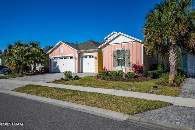 711 Attitude Ave, Daytona Beach, FL 32124 - single story home with board and batten siding, an attached garage, decorative driveway, and a front yard