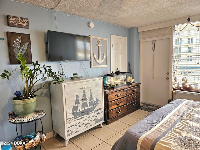 bedroom with light tile patterned floors, a textured ceiling, and multiple windows