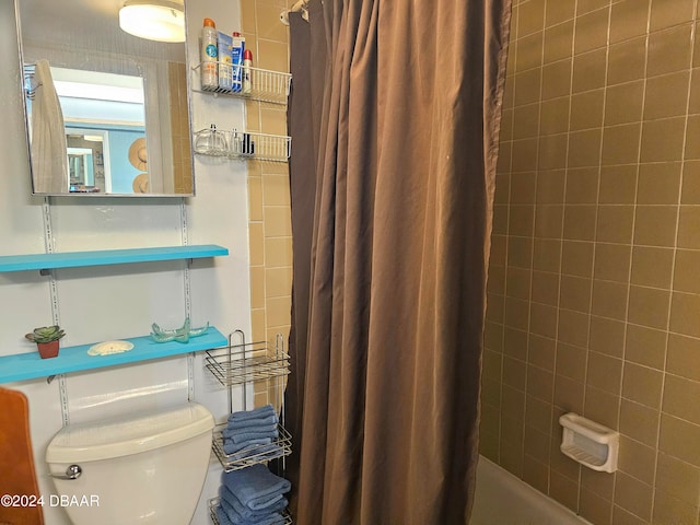 bathroom with shower / bath combination with curtain and toilet