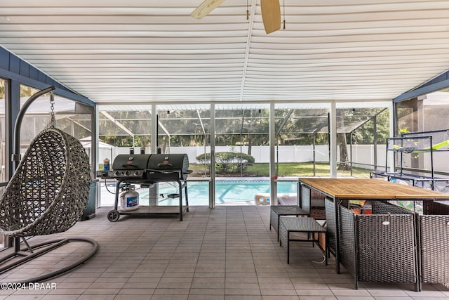 view of pool with a patio, glass enclosure, and grilling area