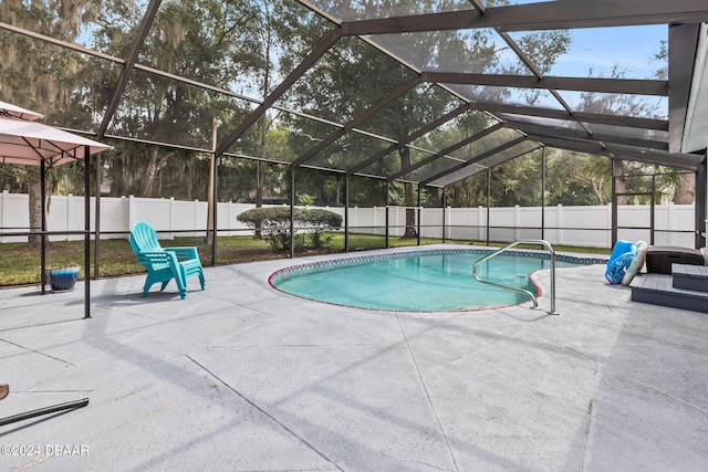 view of swimming pool featuring a patio and a lanai