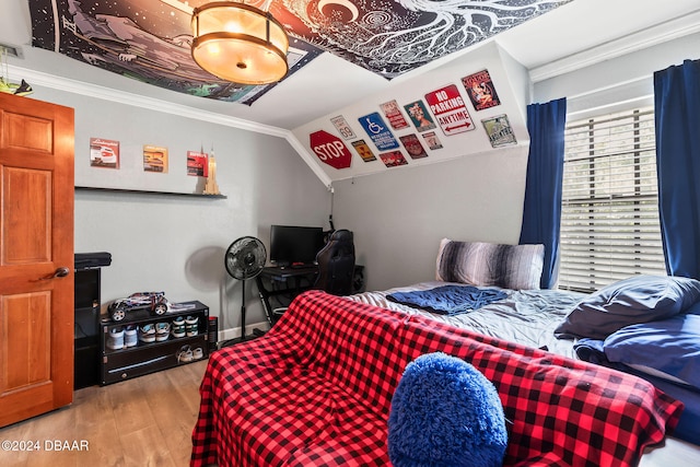 bedroom with ornamental molding, light hardwood / wood-style flooring, and vaulted ceiling