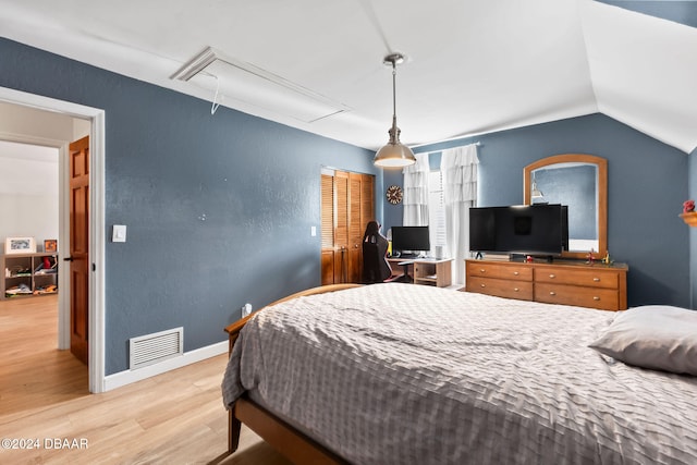 bedroom with light wood-type flooring and vaulted ceiling