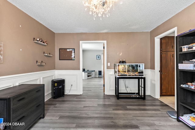 interior space with hardwood / wood-style floors, a textured ceiling, and an inviting chandelier