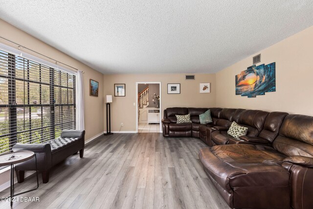 living room with light hardwood / wood-style floors and a textured ceiling