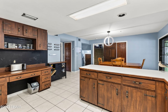 kitchen with decorative backsplash, light tile patterned floors, and decorative light fixtures