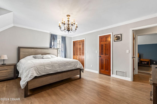 bedroom featuring light hardwood / wood-style flooring, crown molding, and an inviting chandelier