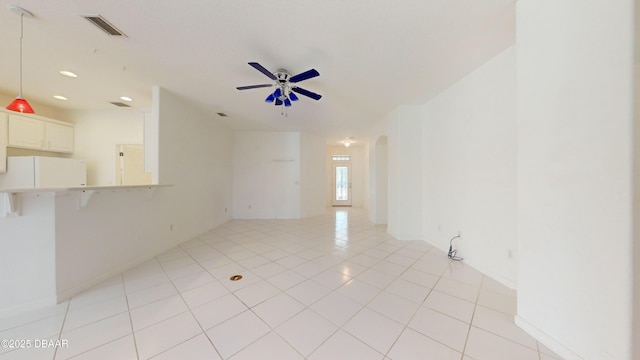 spare room with ceiling fan and light tile patterned floors