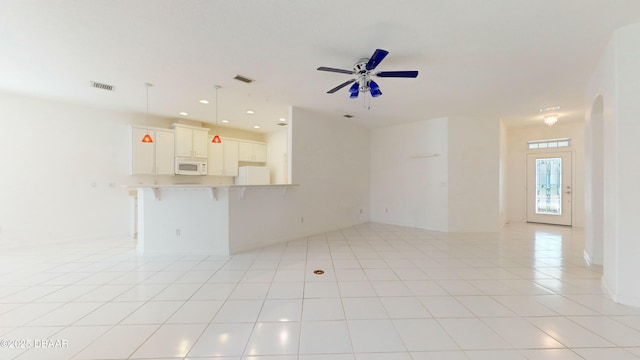 unfurnished living room with ceiling fan and light tile patterned floors