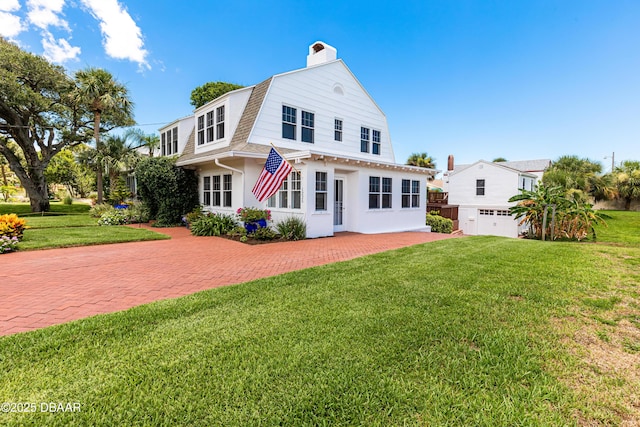 rear view of property with a garage and a lawn