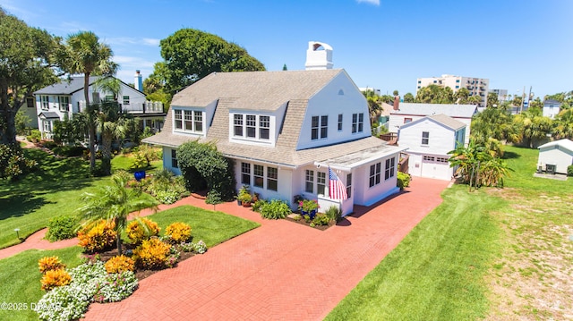 back of property with a garage and a lawn